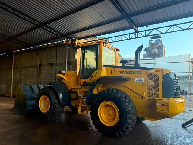 Pá-carregadeira Volvo L110 da SL vista em diagonal, no galpão